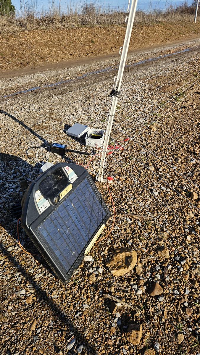 Hautense monitor on a solar energizer by a farm track, winter